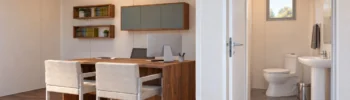 Visualización de una oficina modular con baño integrado, escritorio, dos sillas de visita y aseo independiente con lavabo e inodoro.